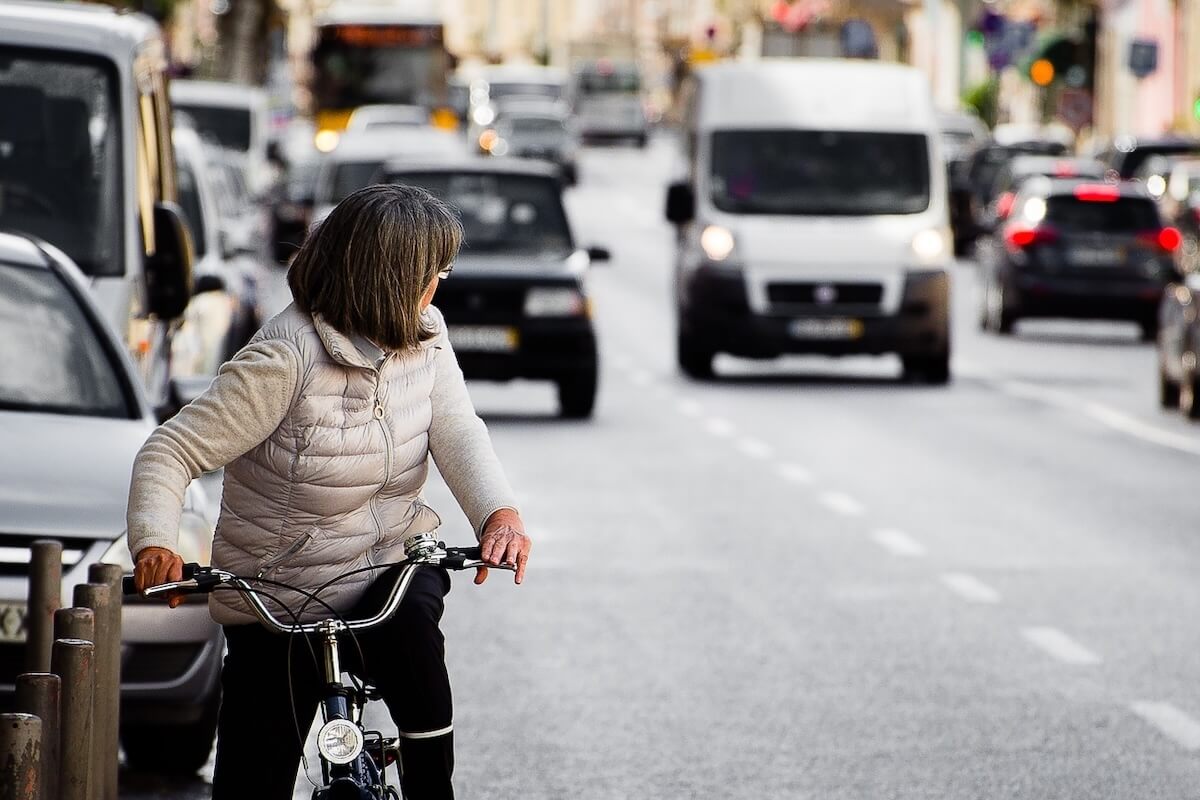 Mulher-bicicleta-cidade-olhar-para-trás